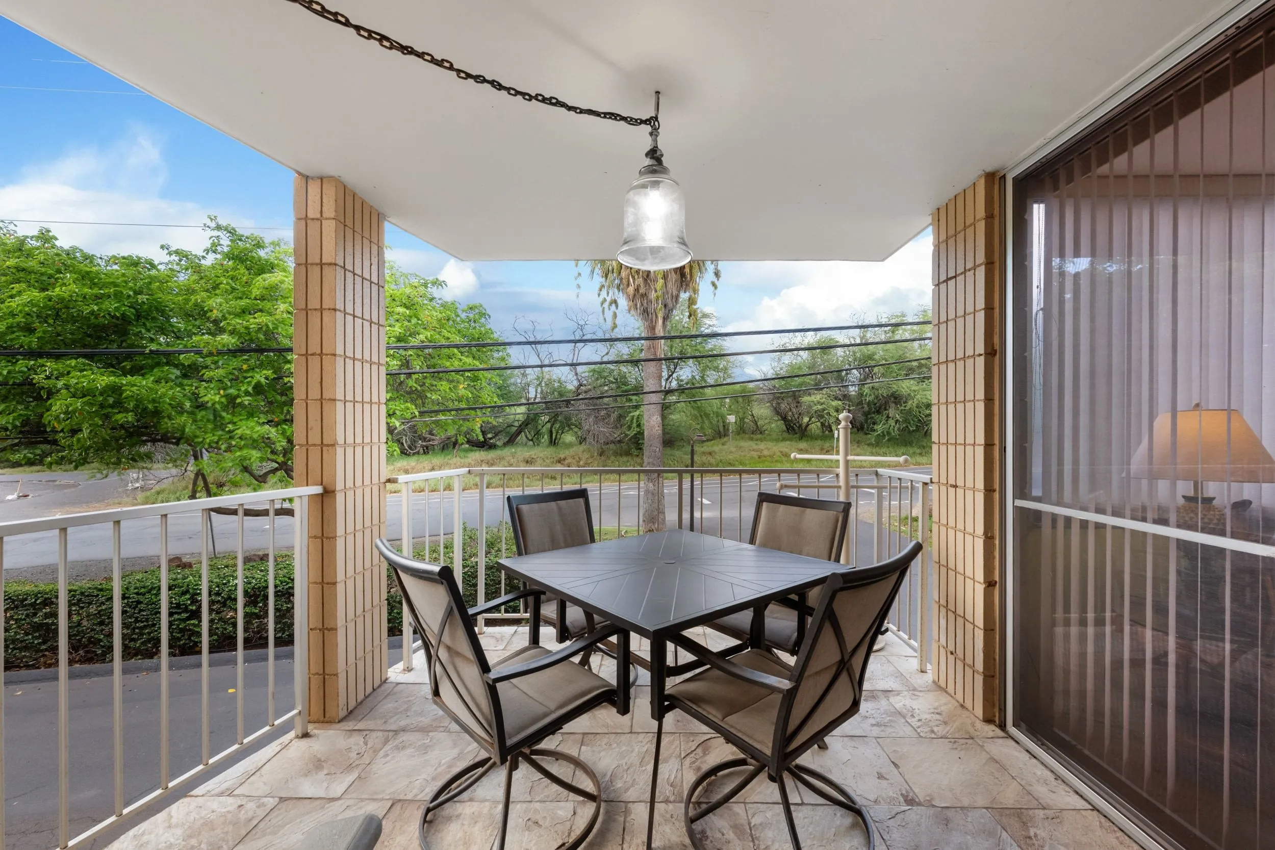 Covered lanai with an outdoor dining table and chairs