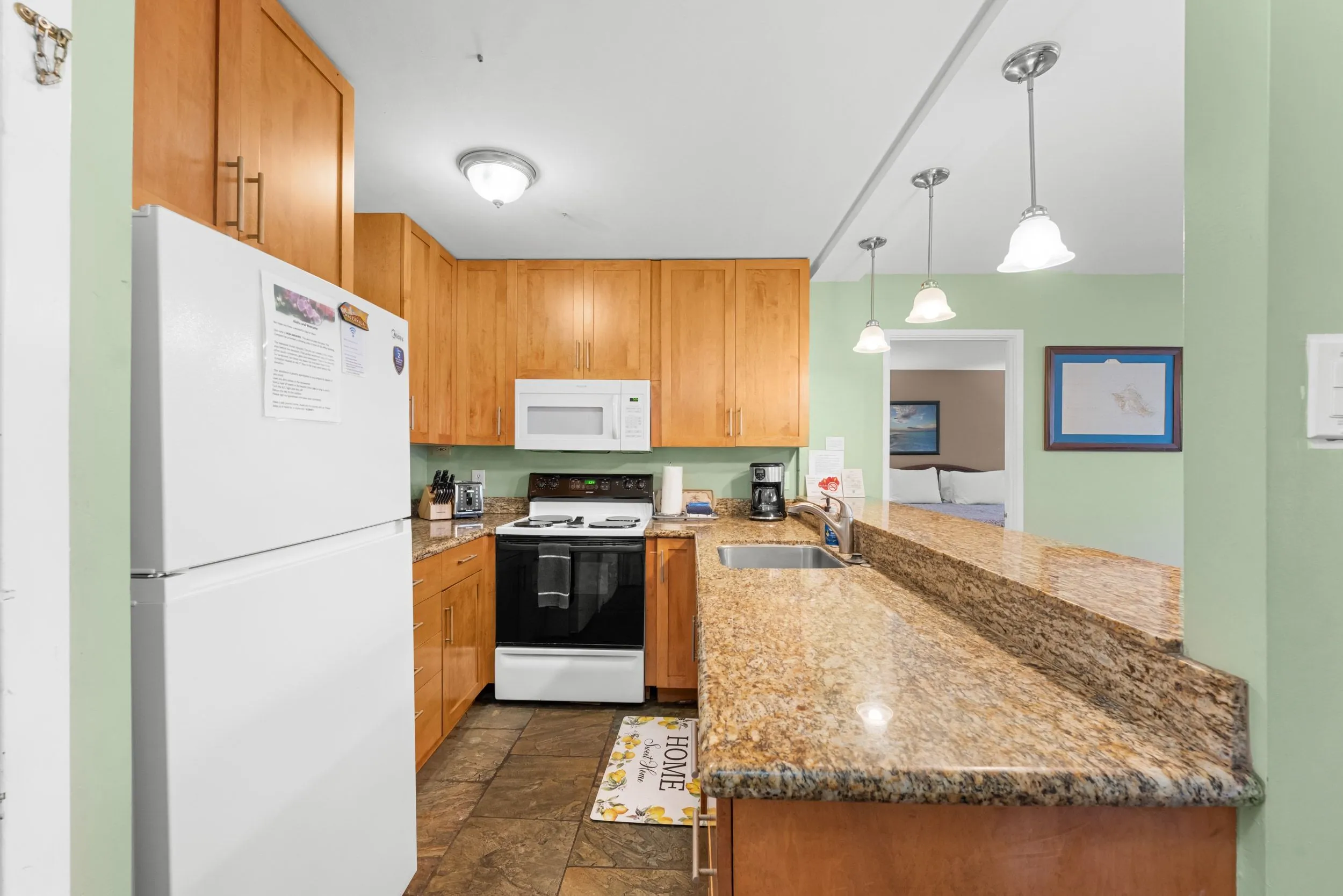 Kitchen with granite counters, an electric stove and a breakfast bar