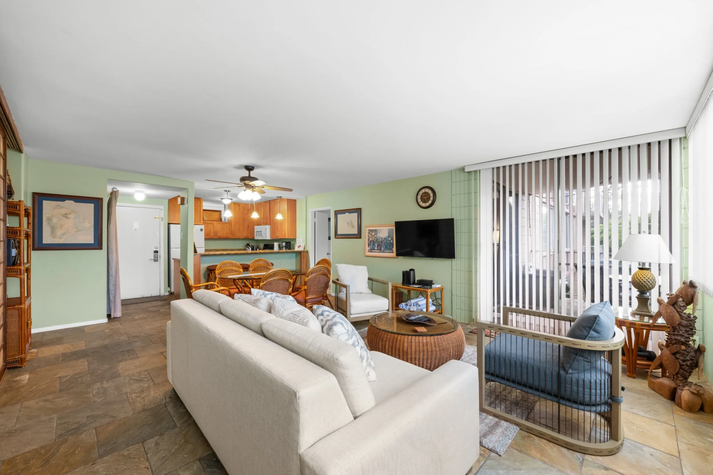 Living room with a sofa, armchairs and the dining area beyond