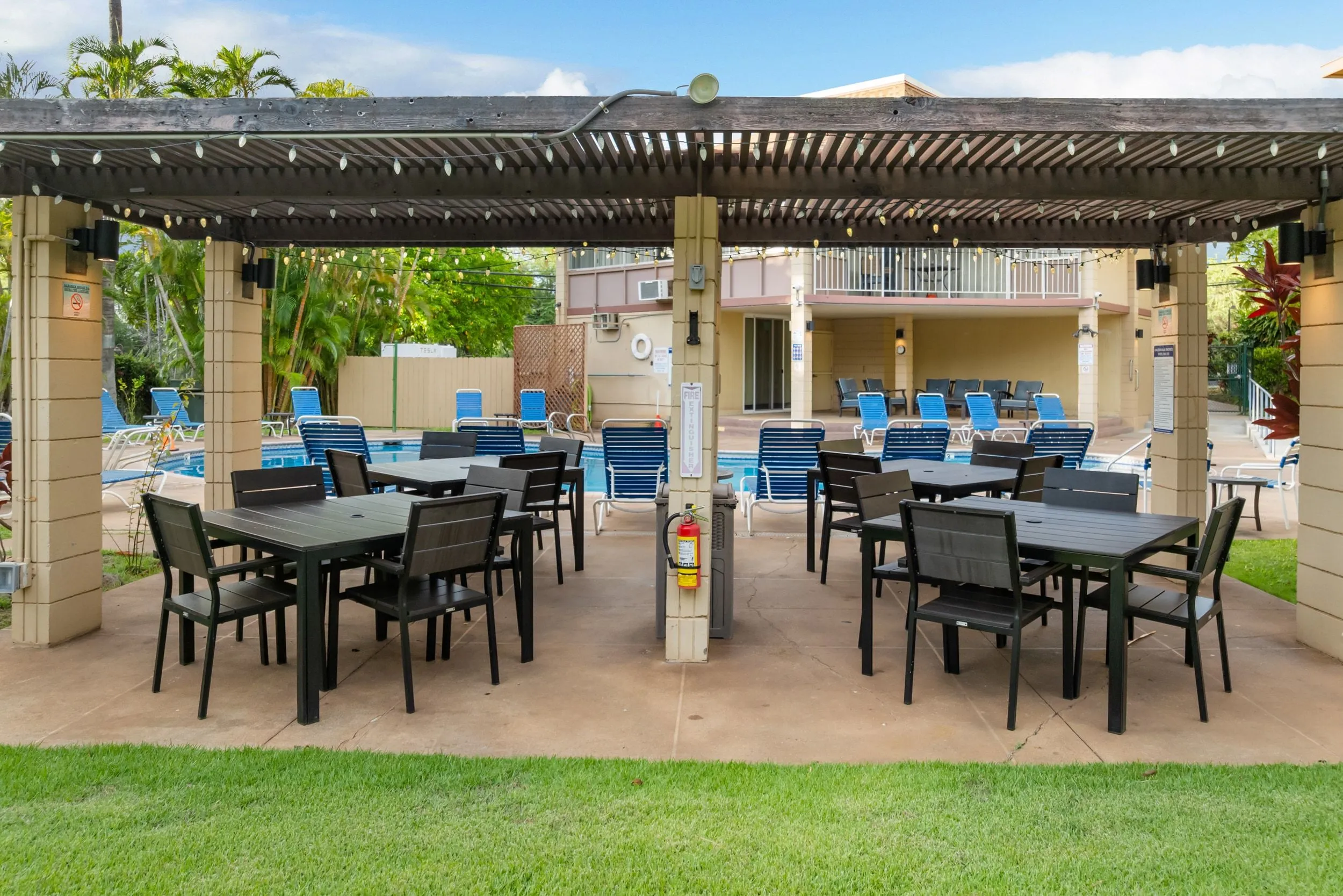 Shaded pergola with tables beside the pool