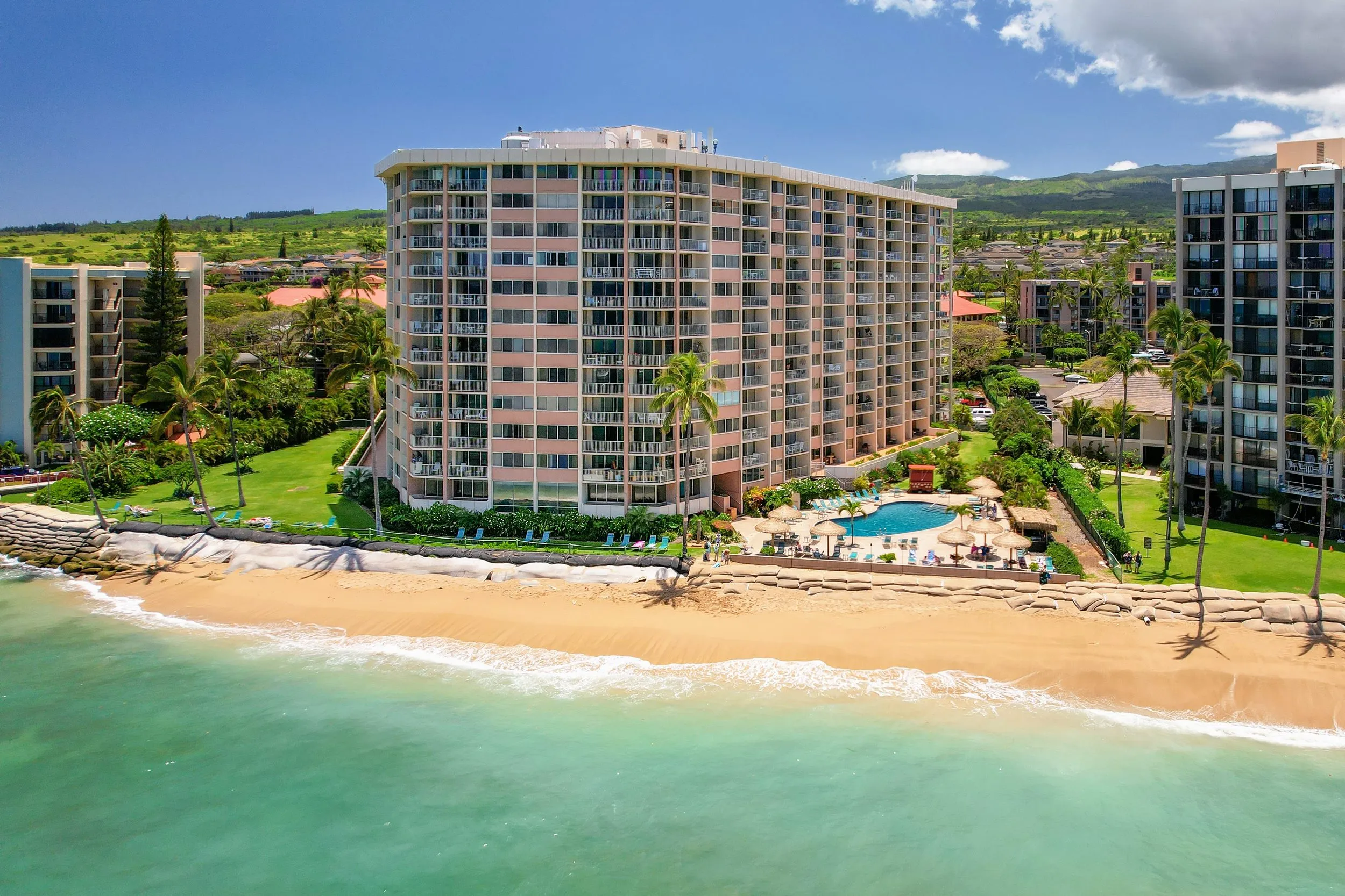 Aerial view of Royal Kahana in summer, with a wide sand beach in front of the resort