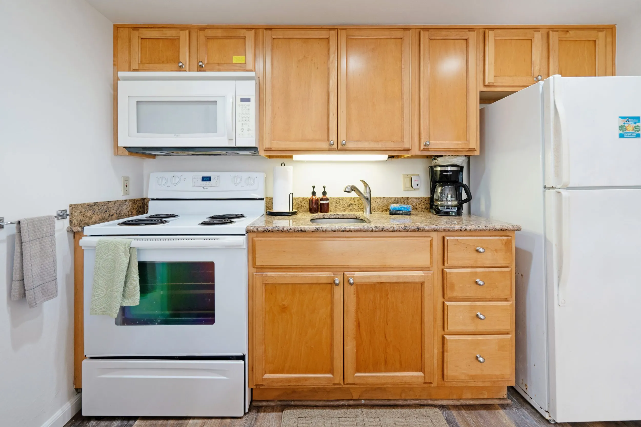 Kitchen with electric stove, microwave, fridge and coffee maker