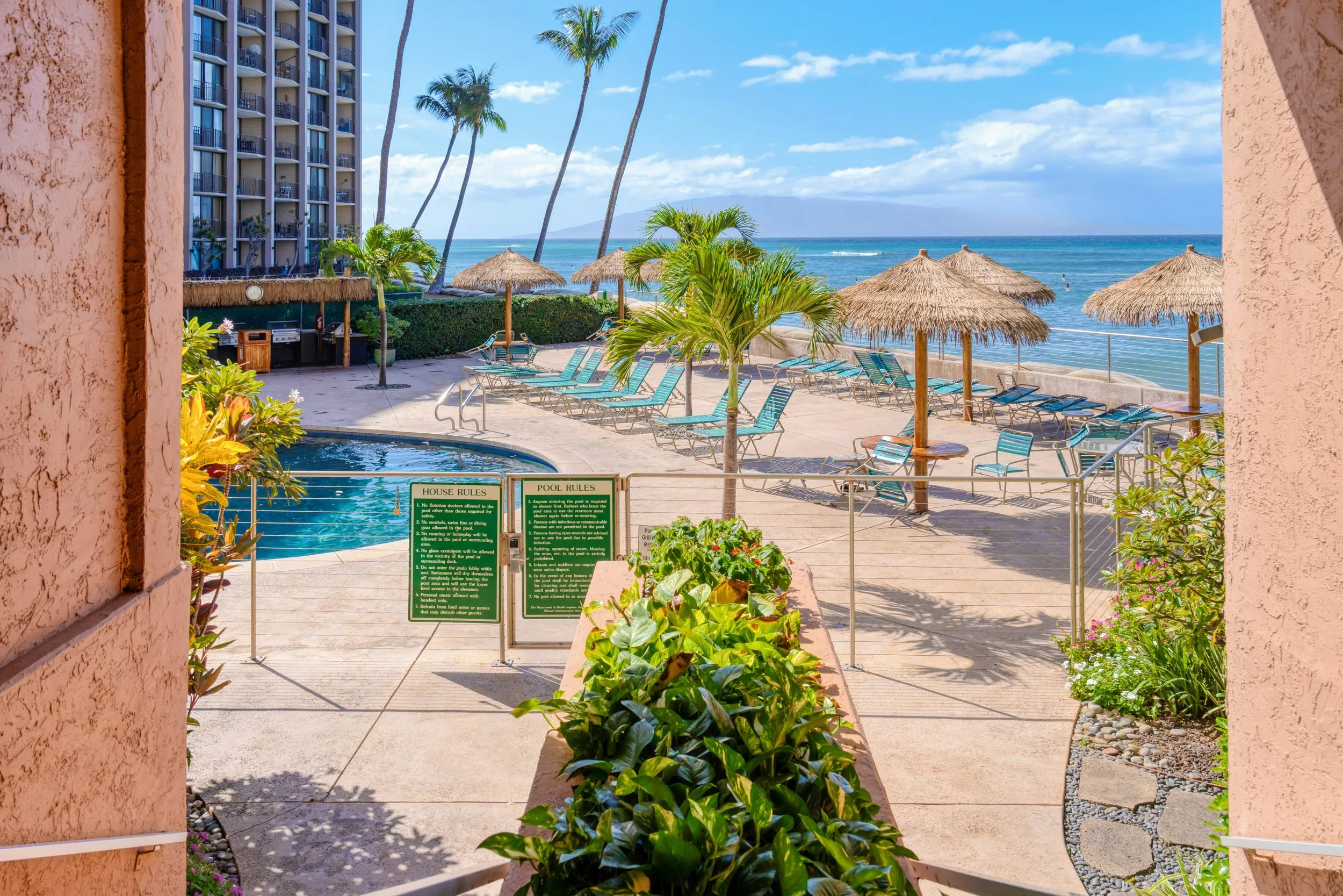 Resort pool and beachfront with thatched umbrellas