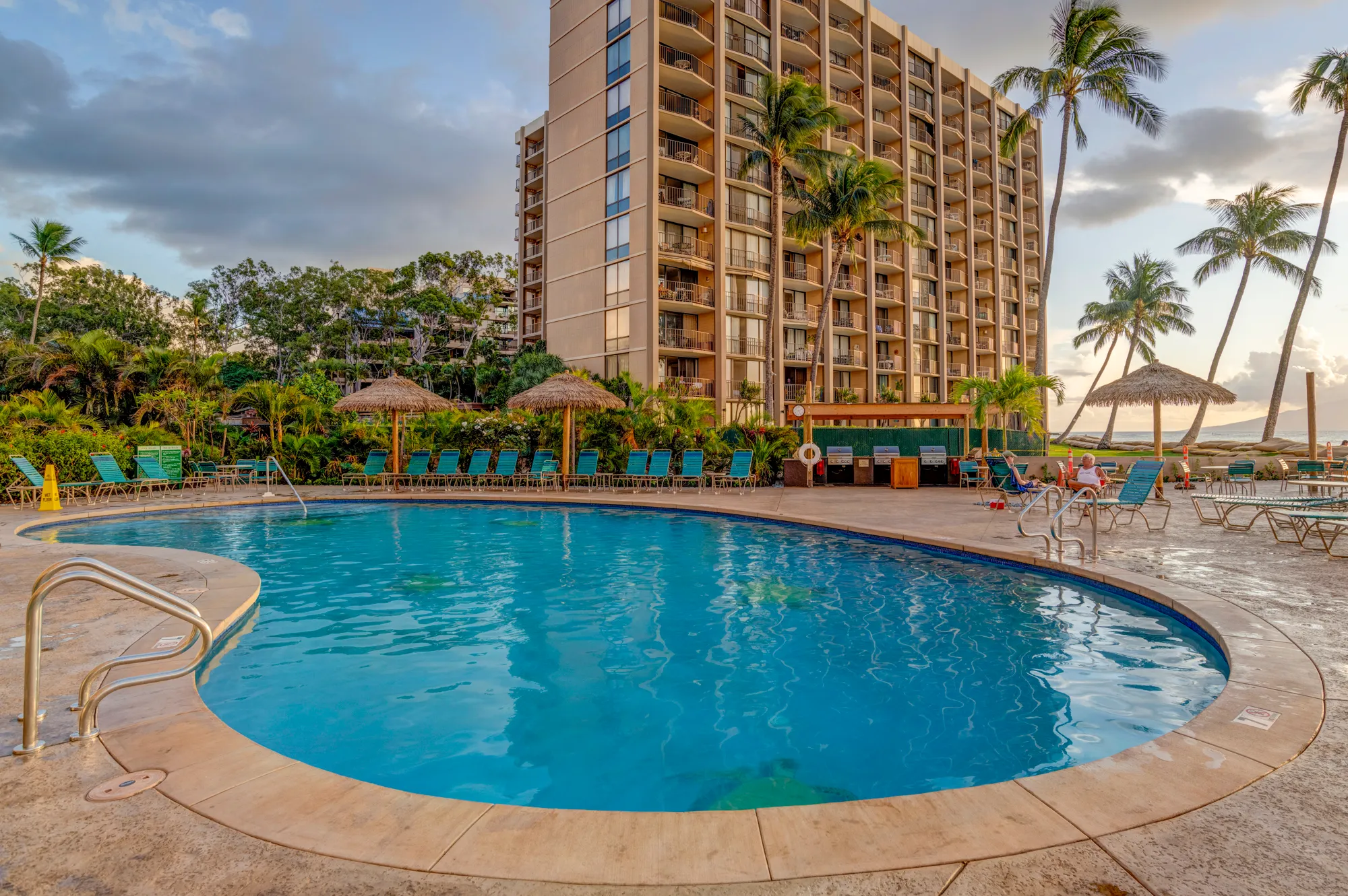 The resort pool at sunset, with the Royal Kahana tower and palms behind it