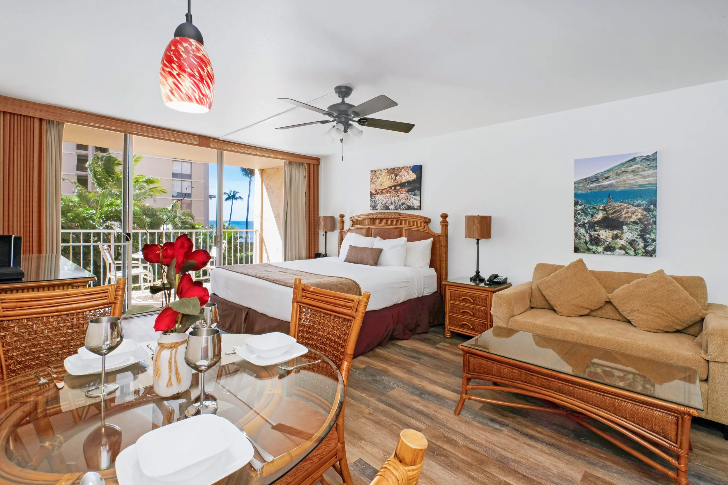 Bed and sofa bed with the open lanai door and the ocean beyond